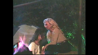 A Brunette and a Blonde with Huge Tits Have Sex in Front of the Campfire