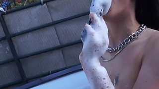 Hot and tattooed brunette is smoking a cigar and masturbating outdoors