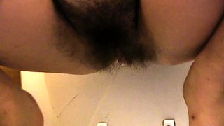 Brunette with glasses masturbates hairy pussy