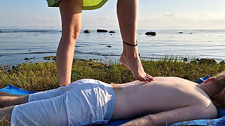 Foot massage by girl with long toes, long slim legs in skirt