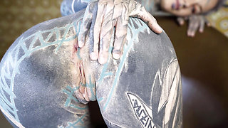 Tattooed woman trying out a machine for anal play