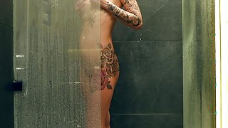 Sexy tattooed girl with big boobs washes her beautiful body in the shower