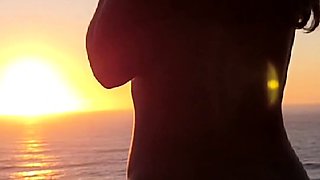 Buxom babe shows off sexy body in nude poses at sunset