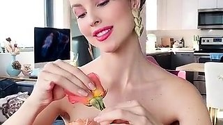 Beautiful busty MILF in red panties plucking rose petals